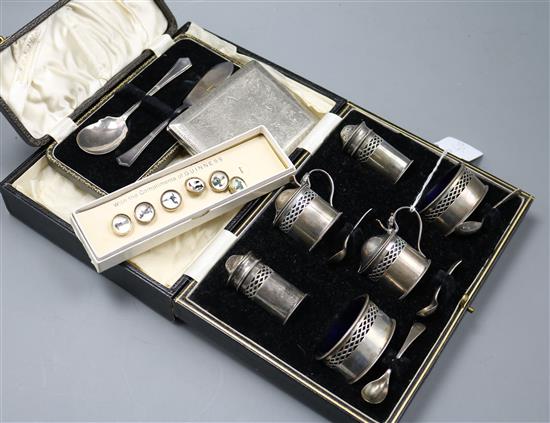 A cased silver six piece condiment set, silver butter knife, silver spoon, guinness buttons and a cigarette case.
